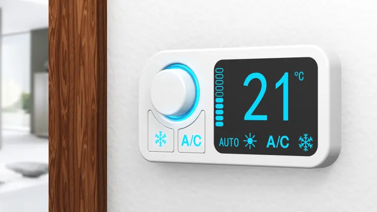 Smart thermostat control unit, blurred living room in the background